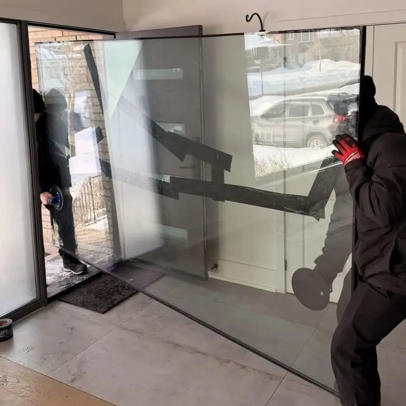 Technicians removing and carrying broken residential glass
