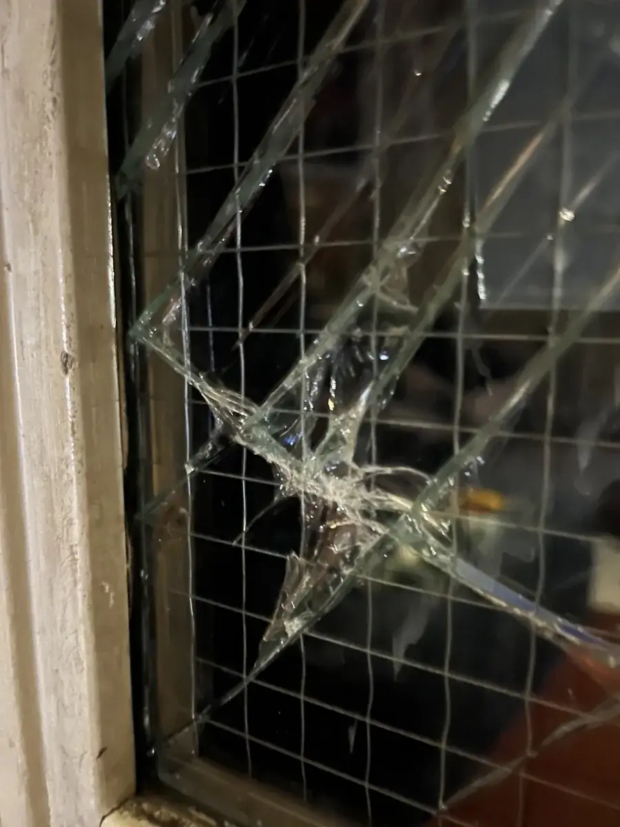 Broken GPW wired glass in a commercial opening before replacement