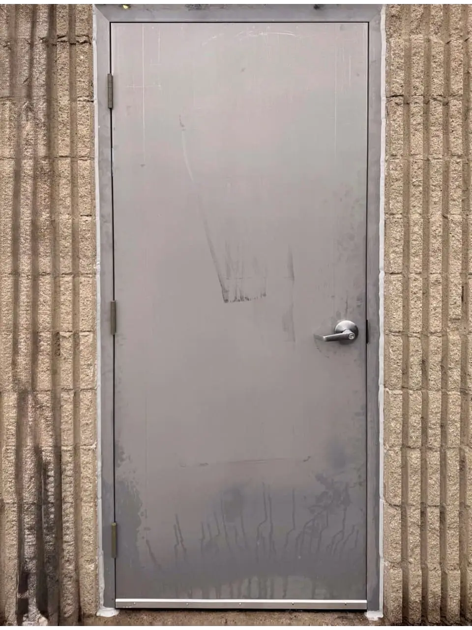 New commercial steel entry door with fresh perimeter caulking installed in Richmond Hill