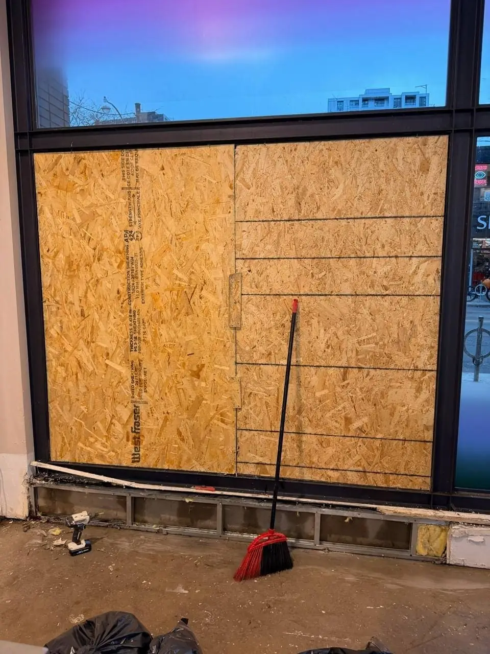 Queen West store window boarded up near Spadina with temporary plywood protection