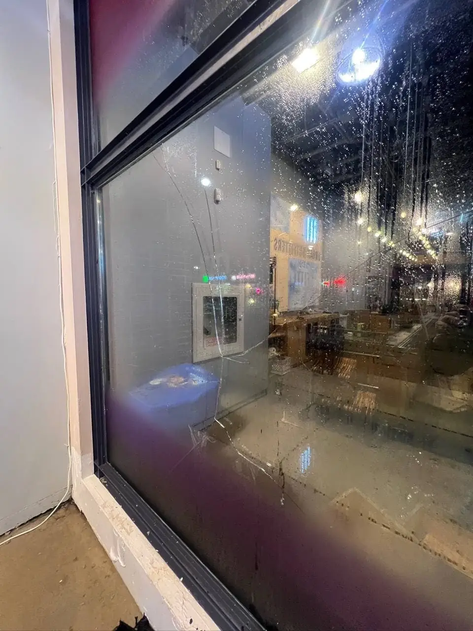 Broken Queen West storefront window near Spadina before emergency board-up