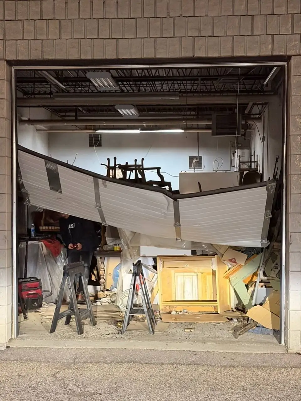Commercial garage door in Oshawa after impact damage and before emergency repair