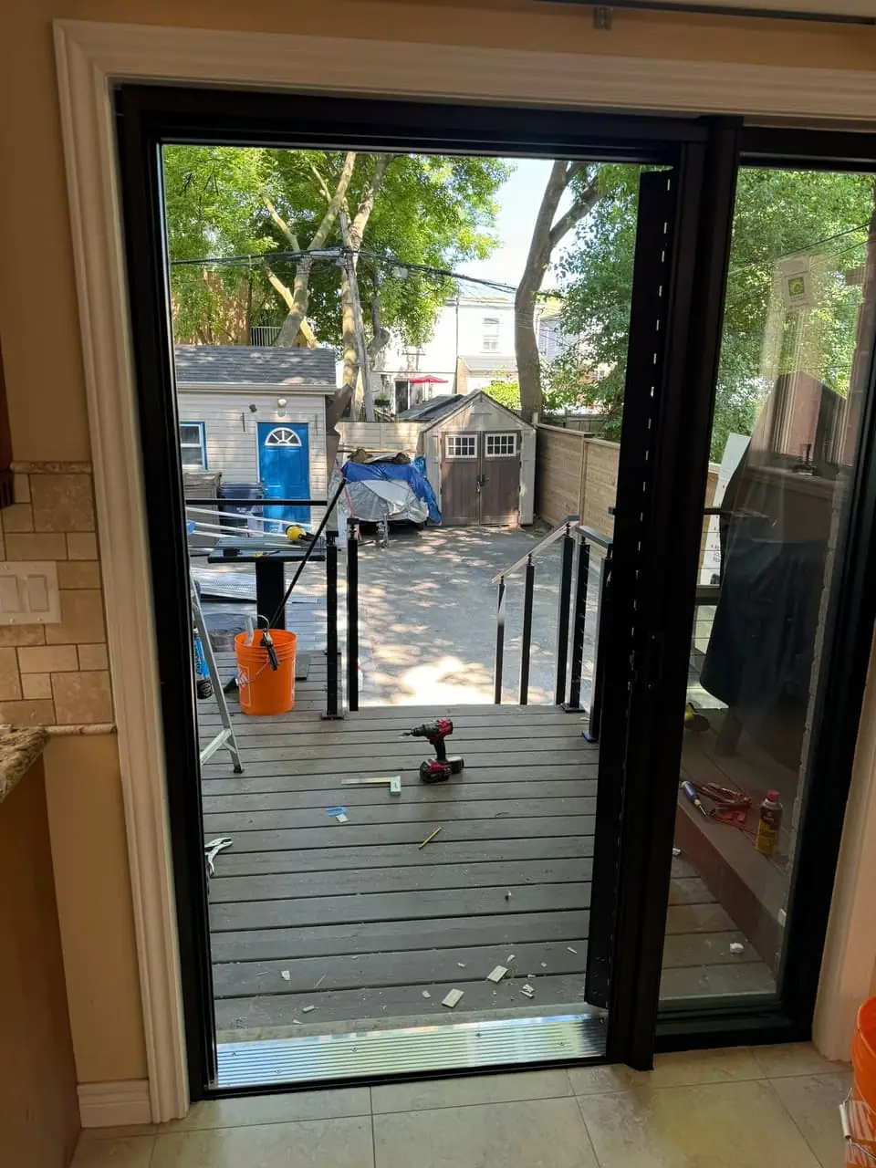 Black hinged garden door and full-height sidelight during installation in Newmarket, viewed from inside.