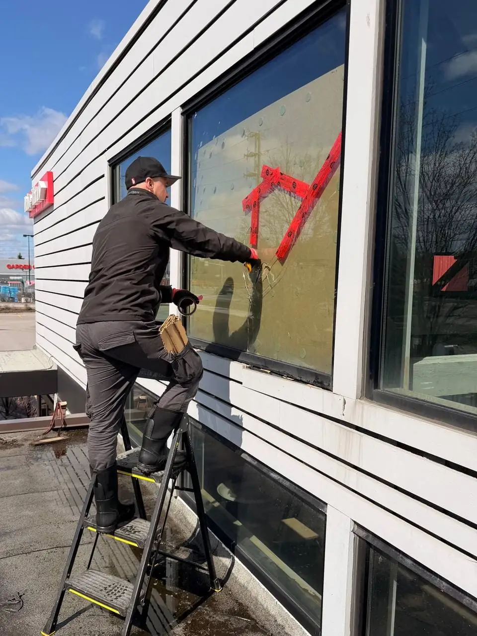 Technician working on the upper restaurant-façade glass replacement in Ajax.