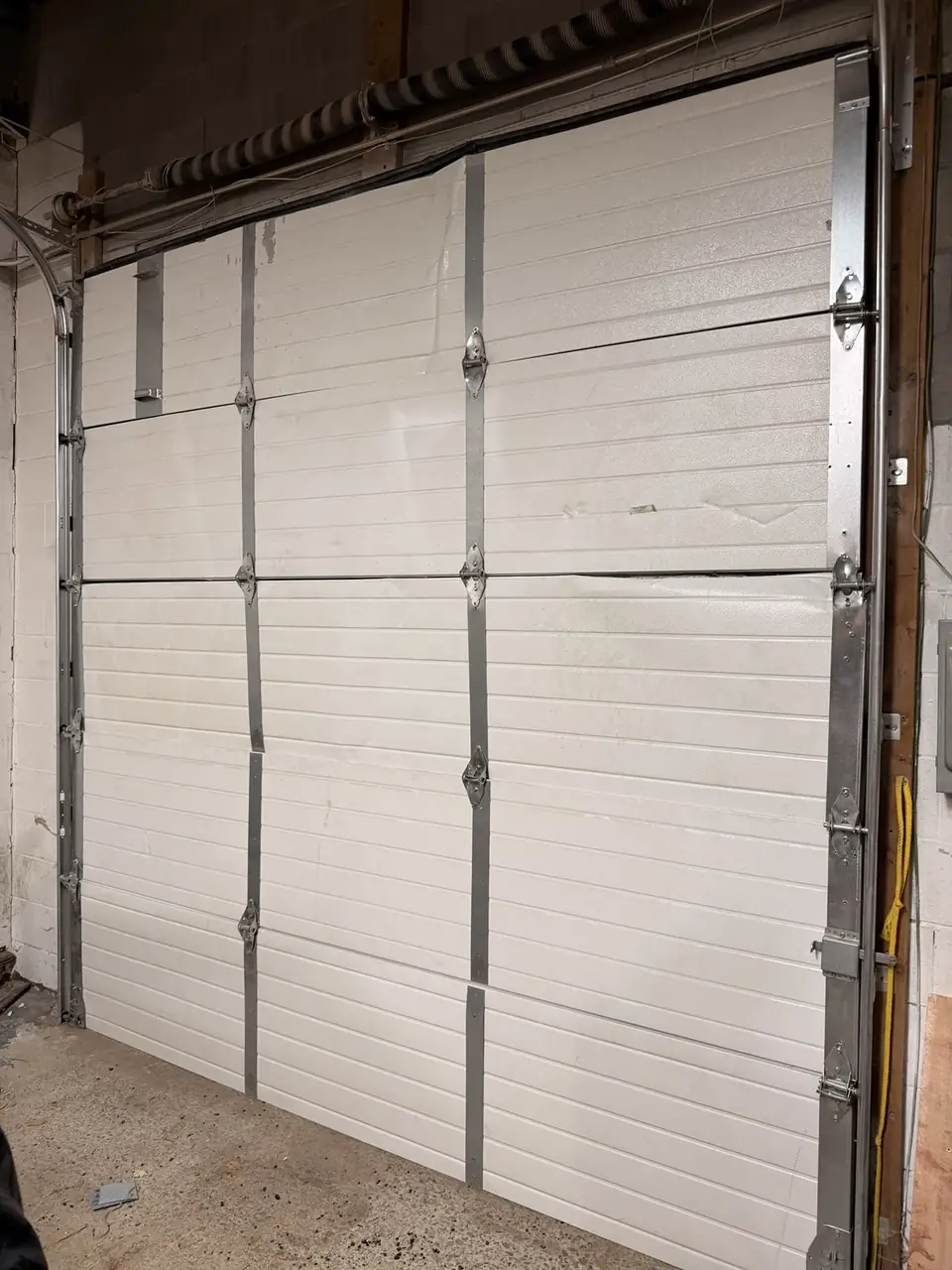 Interior view of stabilized commercial overhead garage door in Oshawa after emergency repair
