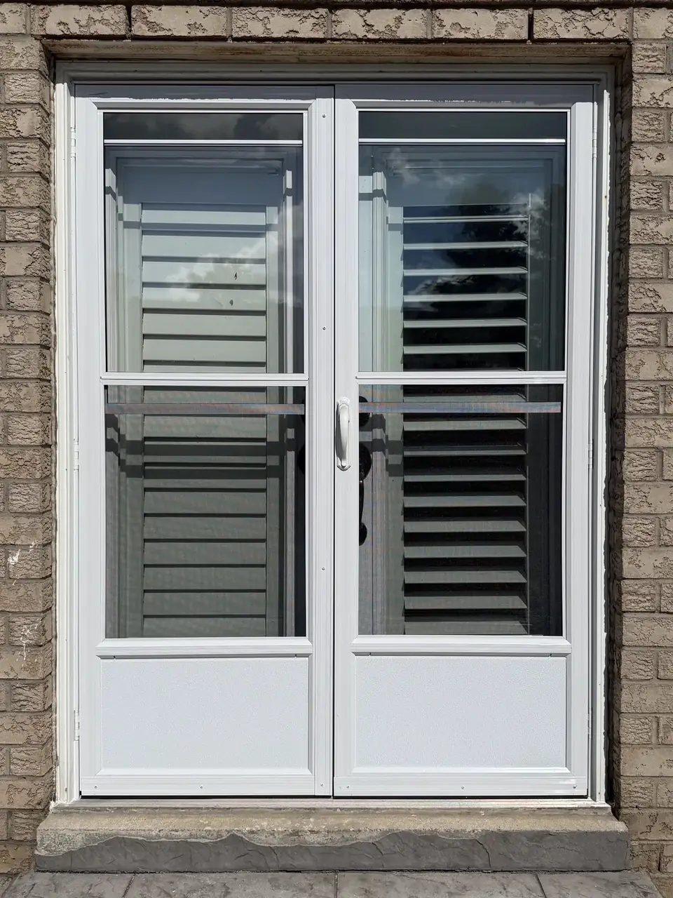 Pair of new white storm doors installed over a double entry in Vaughan