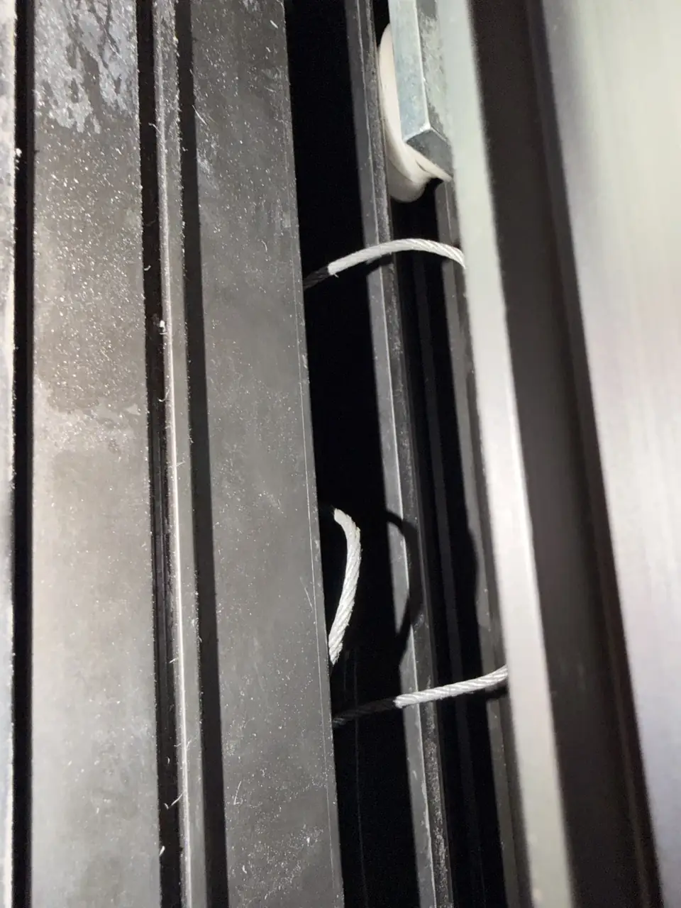 New steel cable installed inside an automatic telescopic sliding door mechanism in Downtown Toronto