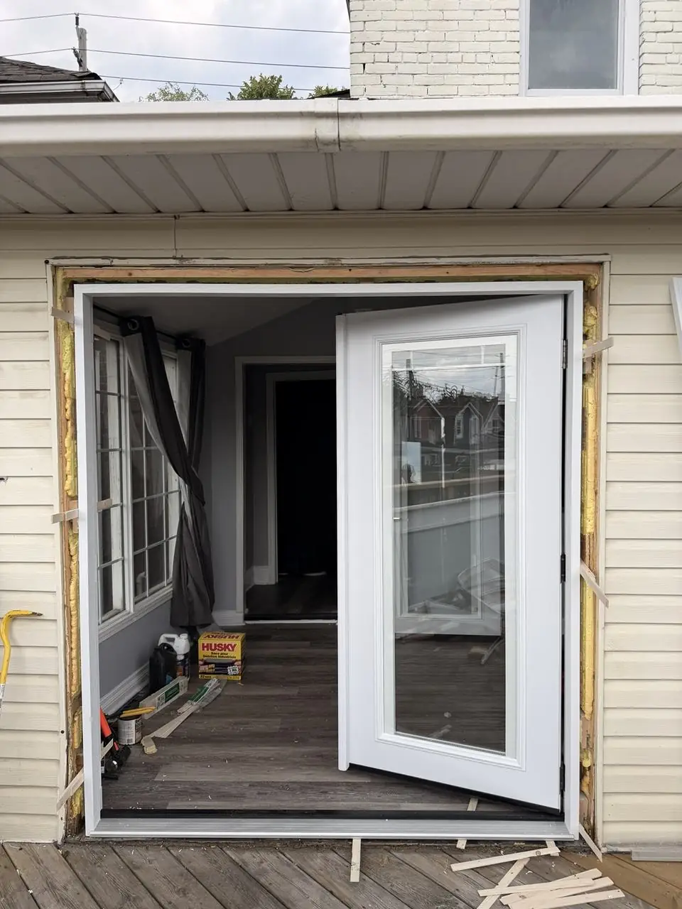 New French patio door frame installed and hinged panel checked for swing before final sealing