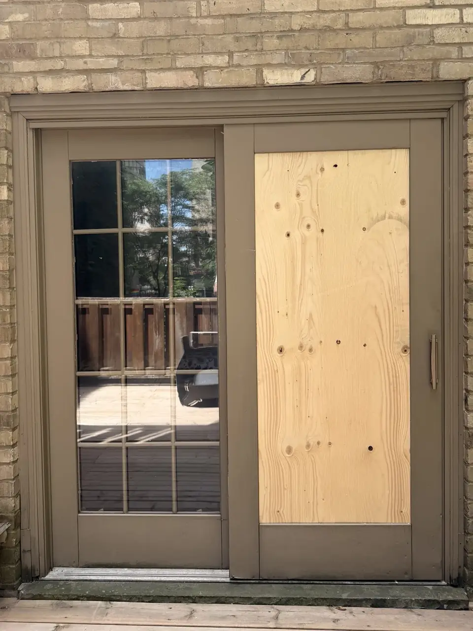 Temporary board-up installed over broken sliding patio door glass in Yorkville Toronto